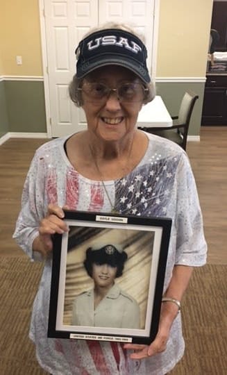 Gayle, Barkley Place resident, poses with her military photo from the 1960s.