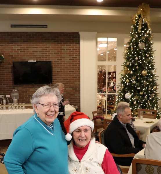 Residents at our senior living community in Madison, AL smiling by the Christmas tree