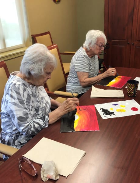 A pair of Oaks residents work on their desert sunset paintings.