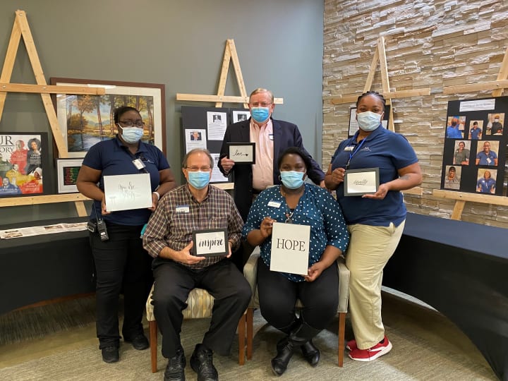 Team members at Woodstock (GA) take a photo together in front of the Black History Month display.