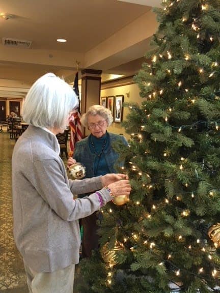 Merrill Gardens at The University decorating the tree together with gold ornaments