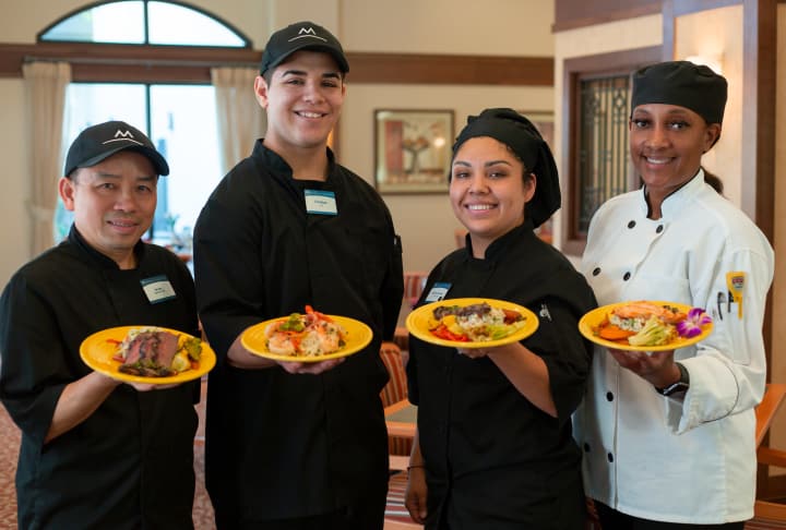 Dining team holding executive chef meals