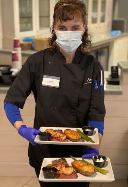 Monterey's (CA) dining lead brings out the delicious food for the residents Father's Day meal.