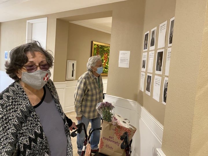 Residents at Gilroy read the historical women's bios posted on the walls of the community.