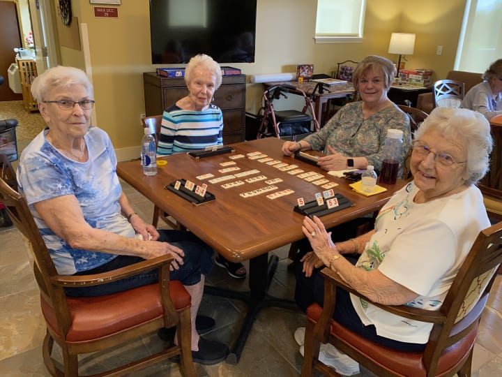 The Groves residents gather around a table and play their favorite game!