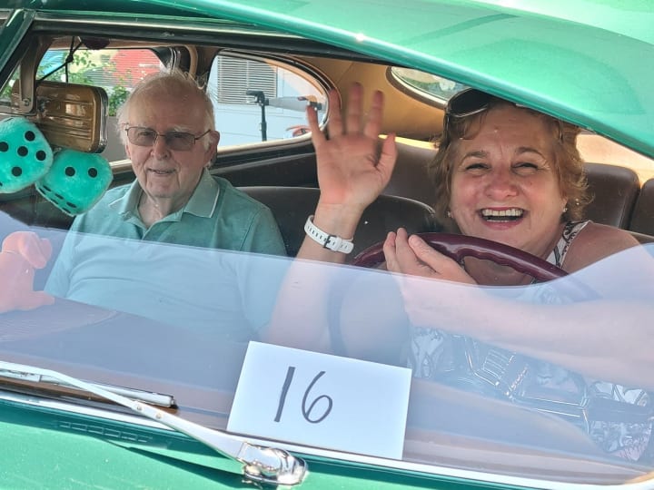 A West Covina (CA) resident and his family member take a picture in a classic car.