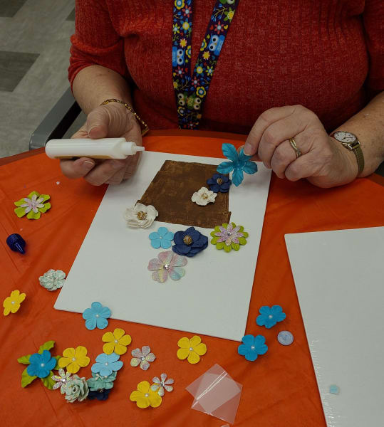 A West Covina resident decides where to put her flowers on her craft.