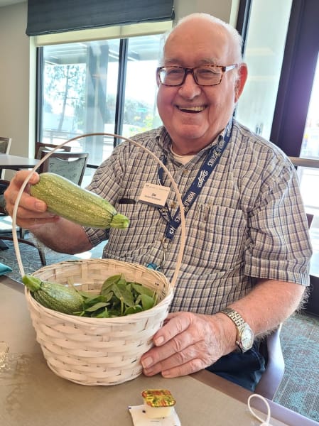 A West Covina resident shows off some fresh squash from the community garden.